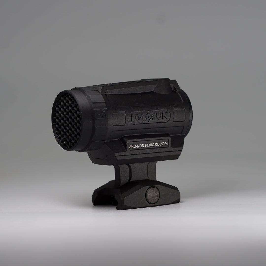 A black tactical-style ARD device with a cylindrical body, perforated front hex pattern, and mounting base, photographed on a smooth light gray studio background. The product appears to be the item itself rather than packaging or an auxiliary diagram.