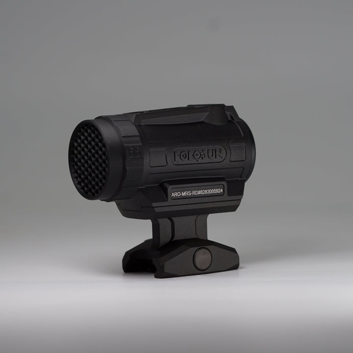 A black tactical-style ARD device with a cylindrical body, perforated front hex pattern, and mounting base, photographed on a smooth light gray studio background. The product appears to be the item itself rather than packaging or an auxiliary diagram.