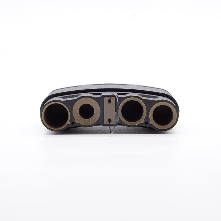 NODSBACK™ unit lying on the ground open showing a battery load out with CR123, AAA, CR2 and AA from left to right. Sleeve color is the dark earth option. 