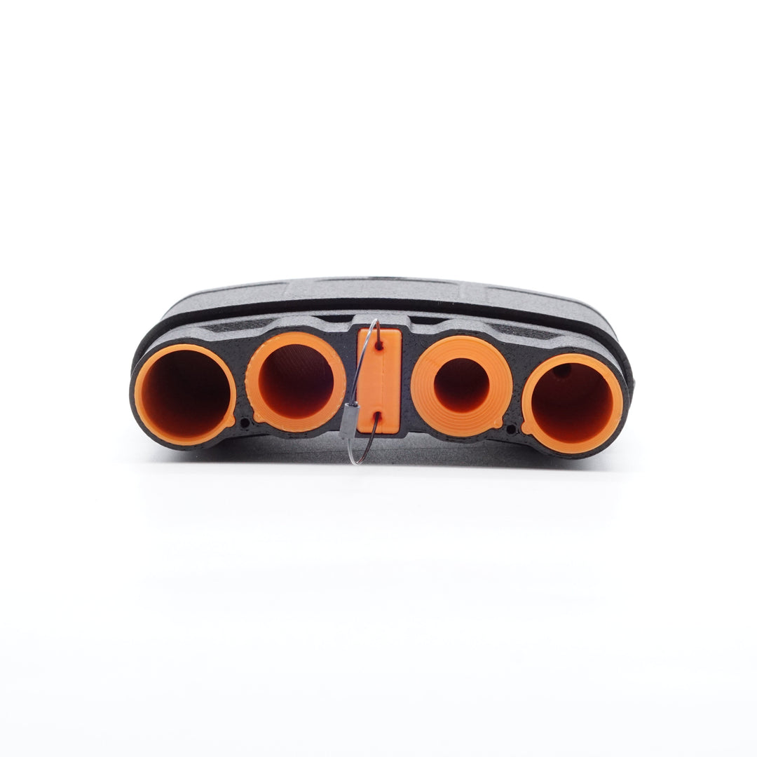 NODSBACK™ unit lying on the ground open showing a battery load out with CR123, AA, AAA and CR2 from left to right. Sleeve color is the hunter orange option. 