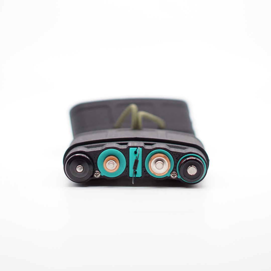 NODSBACK™ unit lying on the ground open showing a battery load out with 18650's, AAA, AA, and CR123's from left to right. Sleeves are the Paradise Blue option. 
