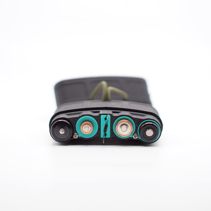 NODSBACK™ unit lying on the ground open showing a battery load out with 18650's, AAA, AA, and CR123's from left to right. Sleeves are the Paradise Blue option. 