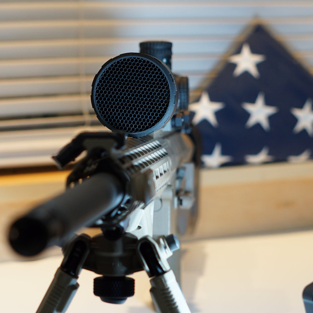 Paradise Tactical ARD installed on a Nightforce scope on an AR10 6.5 Creedmoor with an American flag in the background
