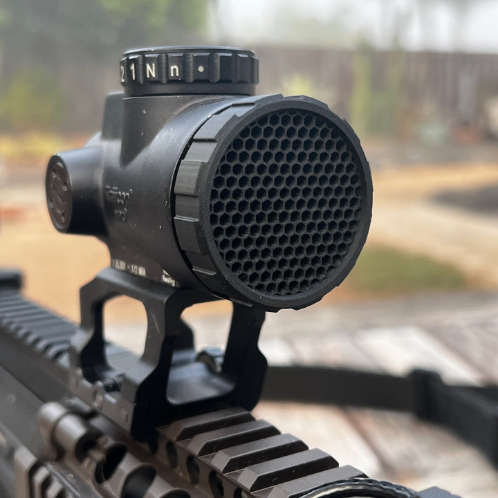 A black anti reflective device (ARD) designed for a Trijicon MRO red dot optic, shown mounted on the optic.