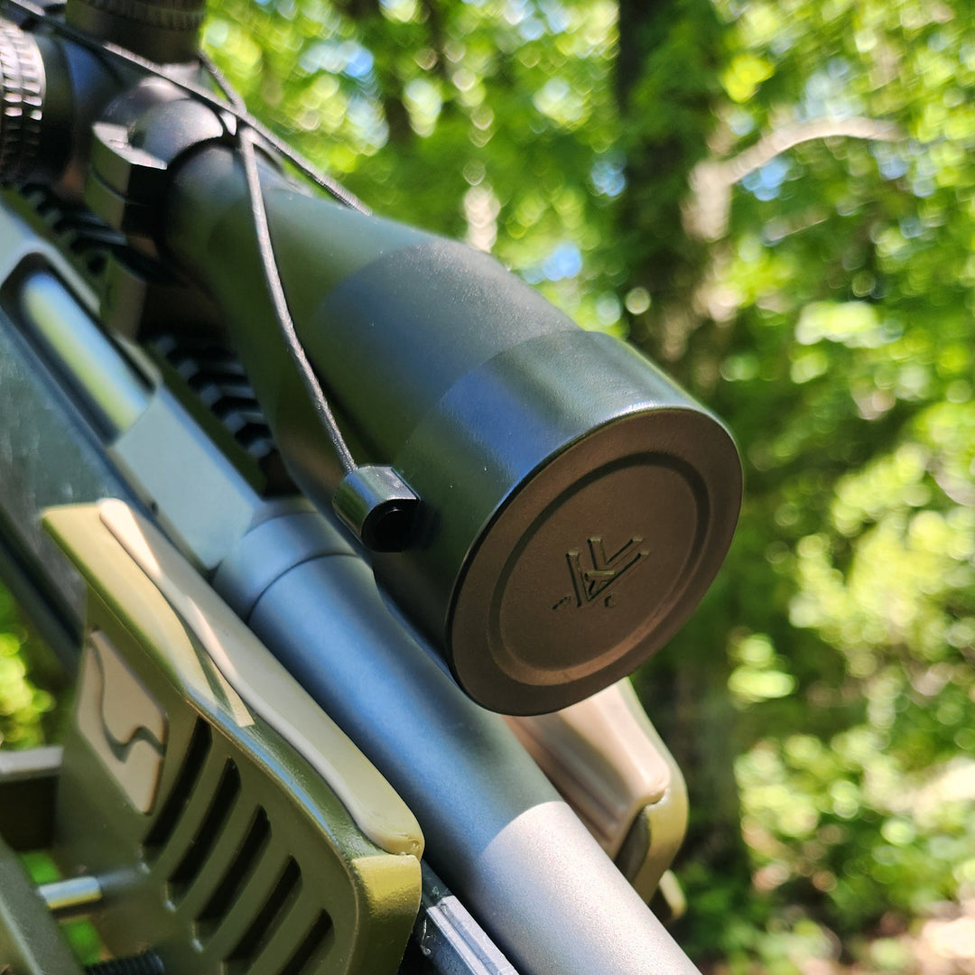 Covered up matte black Vortex Crossfire II ARD on hunting rifle with woodland background