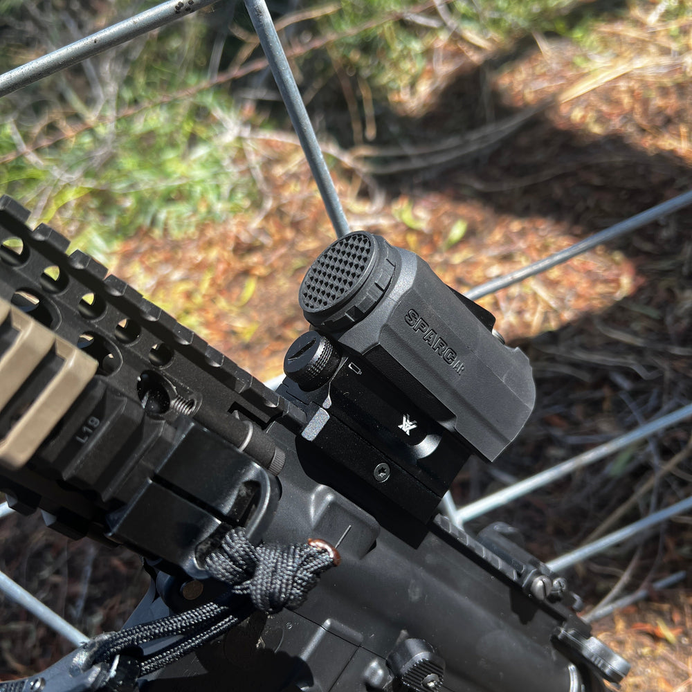Field Image of a Vortex Sparc AR black antireflective device (ARD) designed for a Vortex Sparc AR red dot optic, shown installed on an optic with a hexagonal pattern on the front. Optic snaps onto place and allows for full use of OEM dust covers.